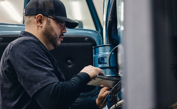 Volvo employee looking at truck diagnostics on a computer.