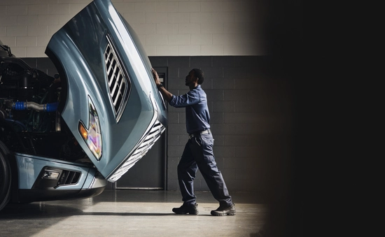 Volvo employee closing a truck hood.